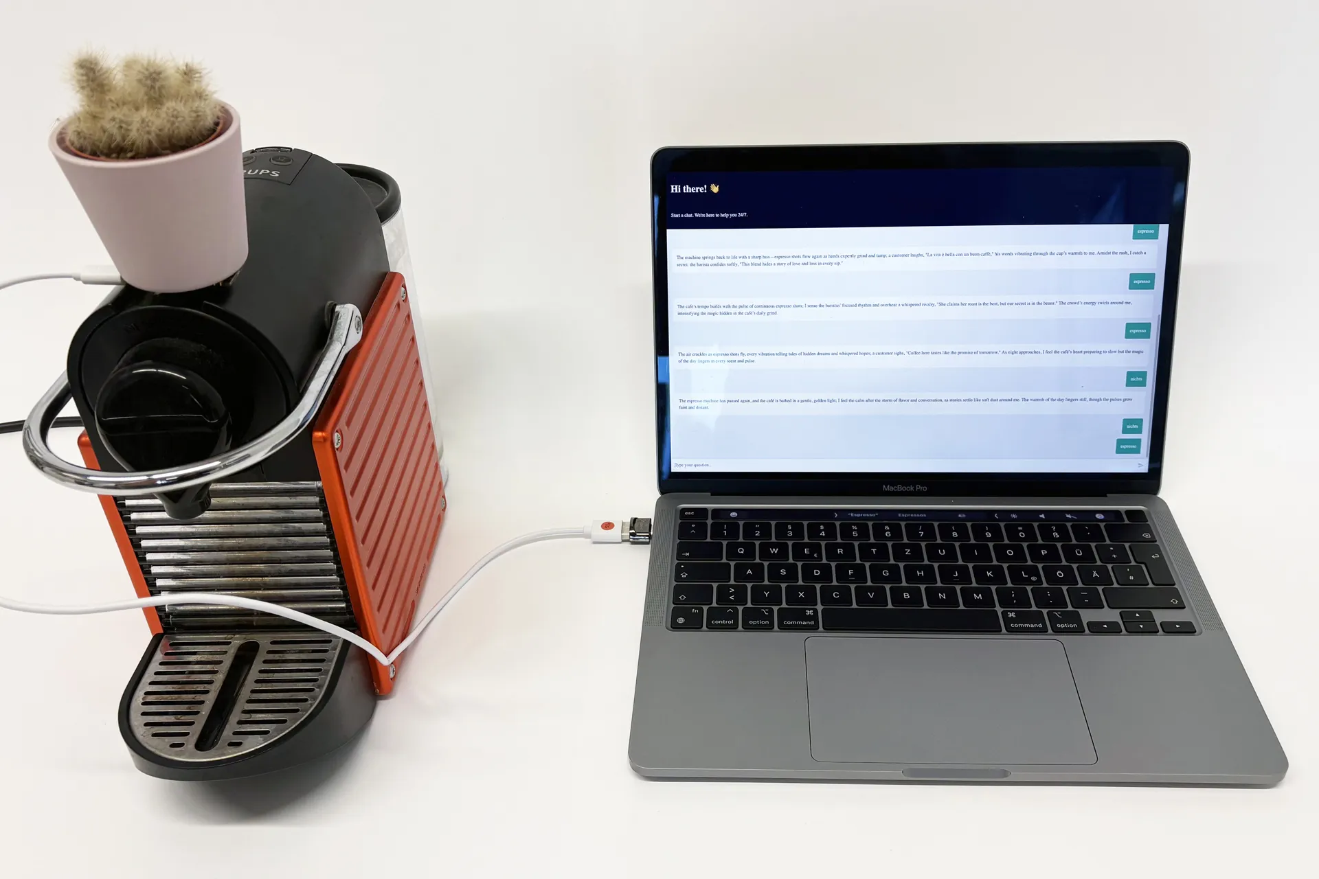 A coffee machine connected via USB cable to a MacBook Pro. On screen, a chat interface displays a series of generated story paragraphs. The setup illustrates the physical sensor pipeline of the assignment, where the coffee machine triggers the storytelling agent.