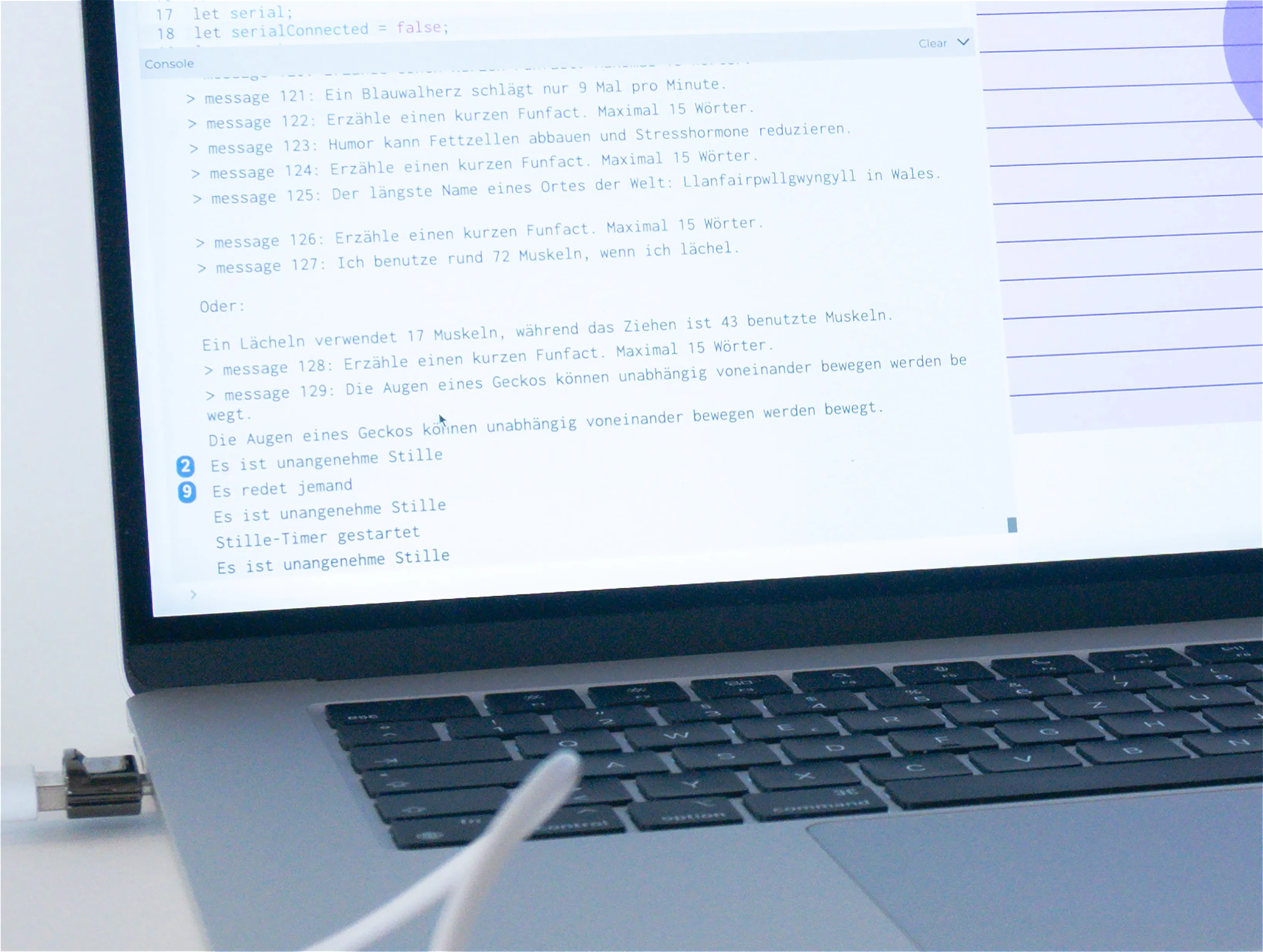 Social Spark prototype detecting conversational silence: Close-up view of laptop screen showing German-language code with pre-programmed conversation starters including jokes and fun facts.